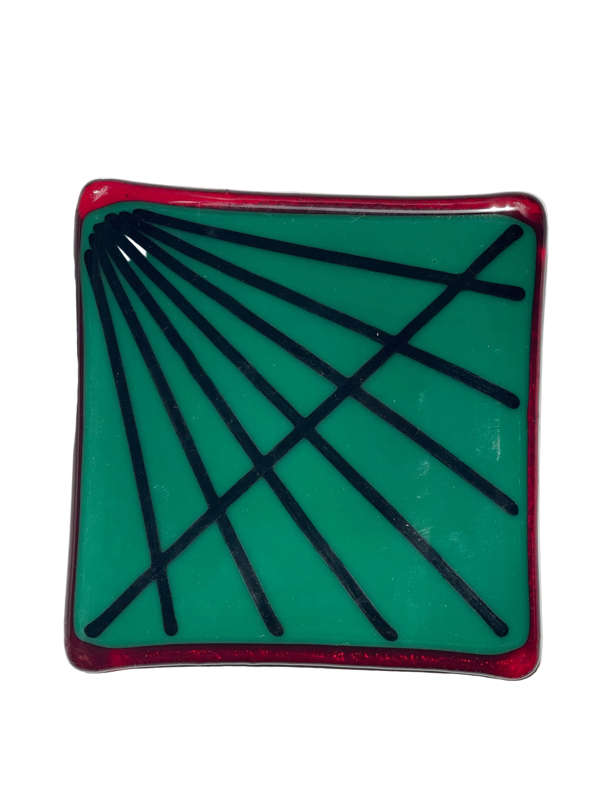 A square green glass plate with a red border and black geometric line patterns.