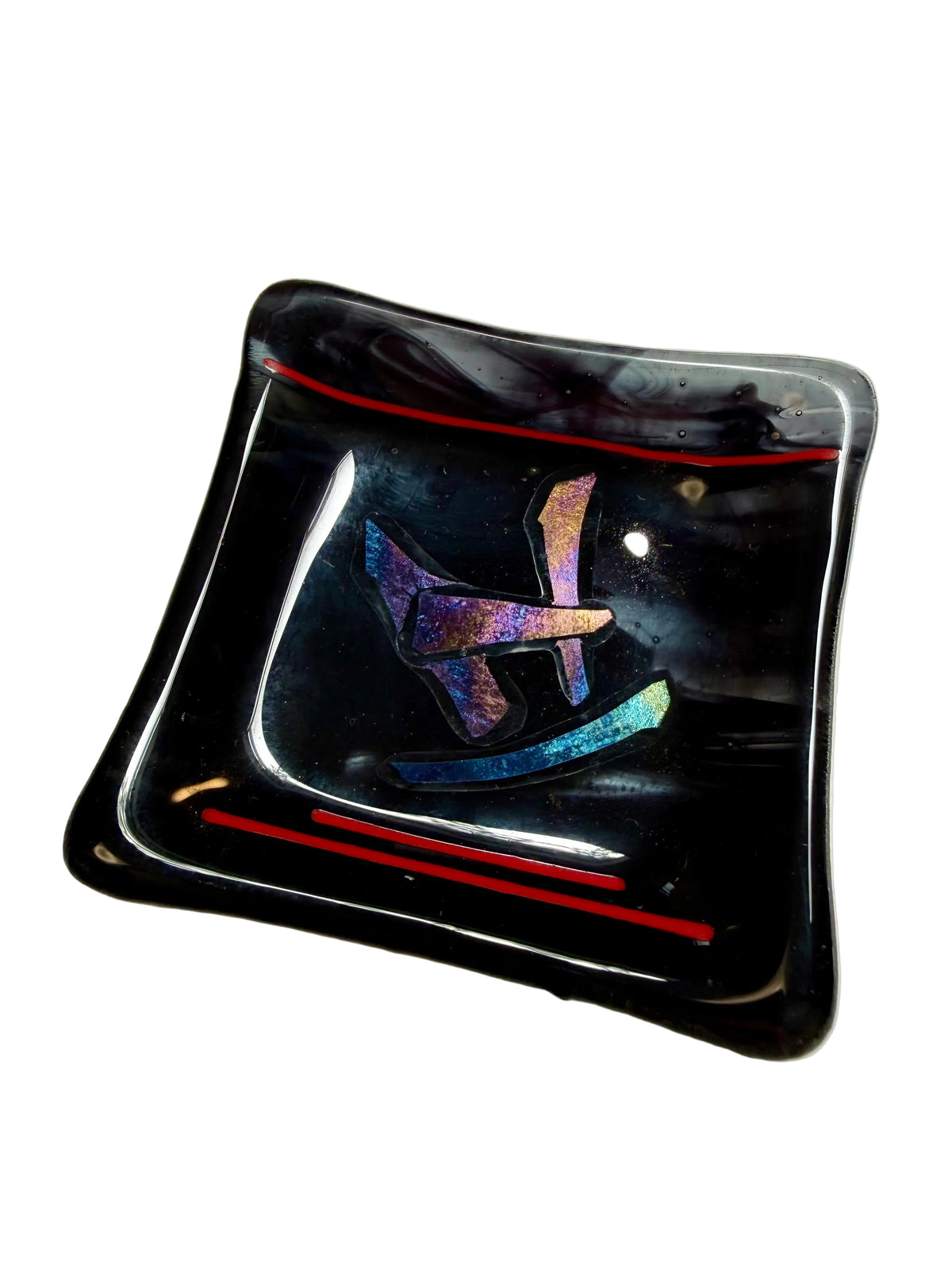 A square black glass dish with rounded corners, featuring a central iridescent blue and purple geometric design and two thin red lines near the top and bottom edges.