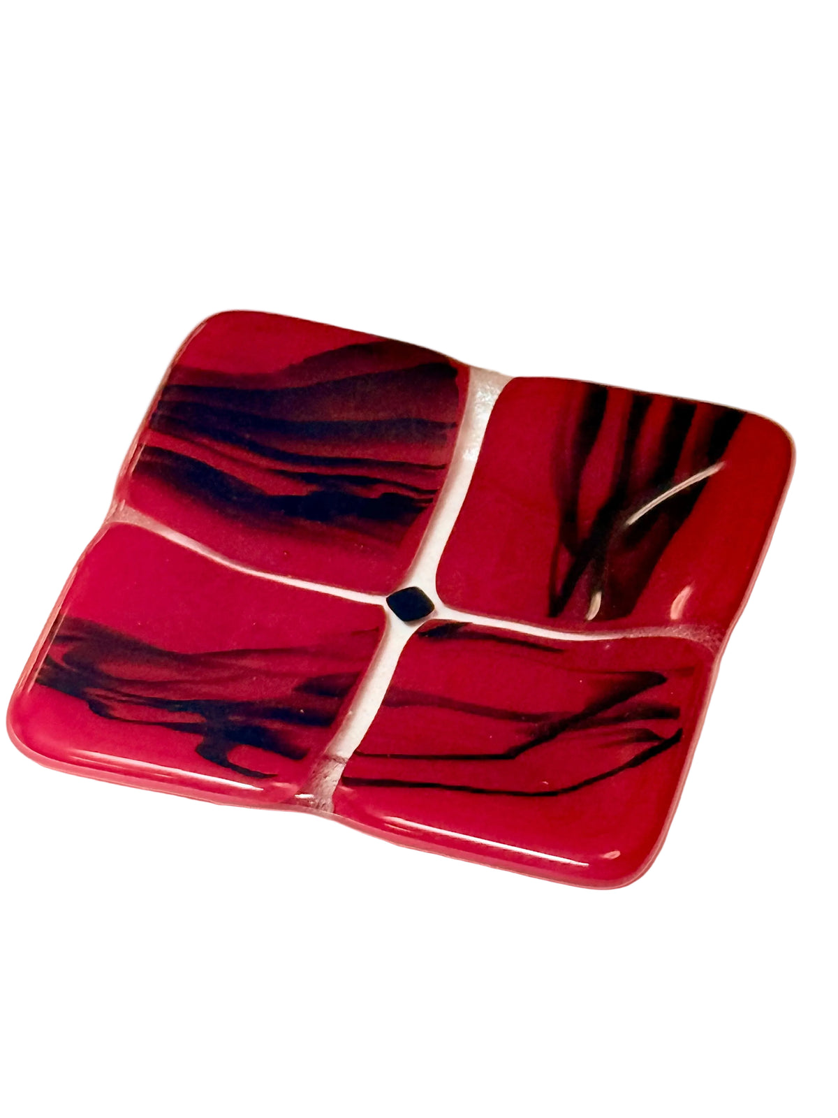 A square four-piece glass dish with rounded corners, featuring a vibrant red and dark black marbled pattern.